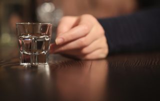 hand reaching out for shot glass