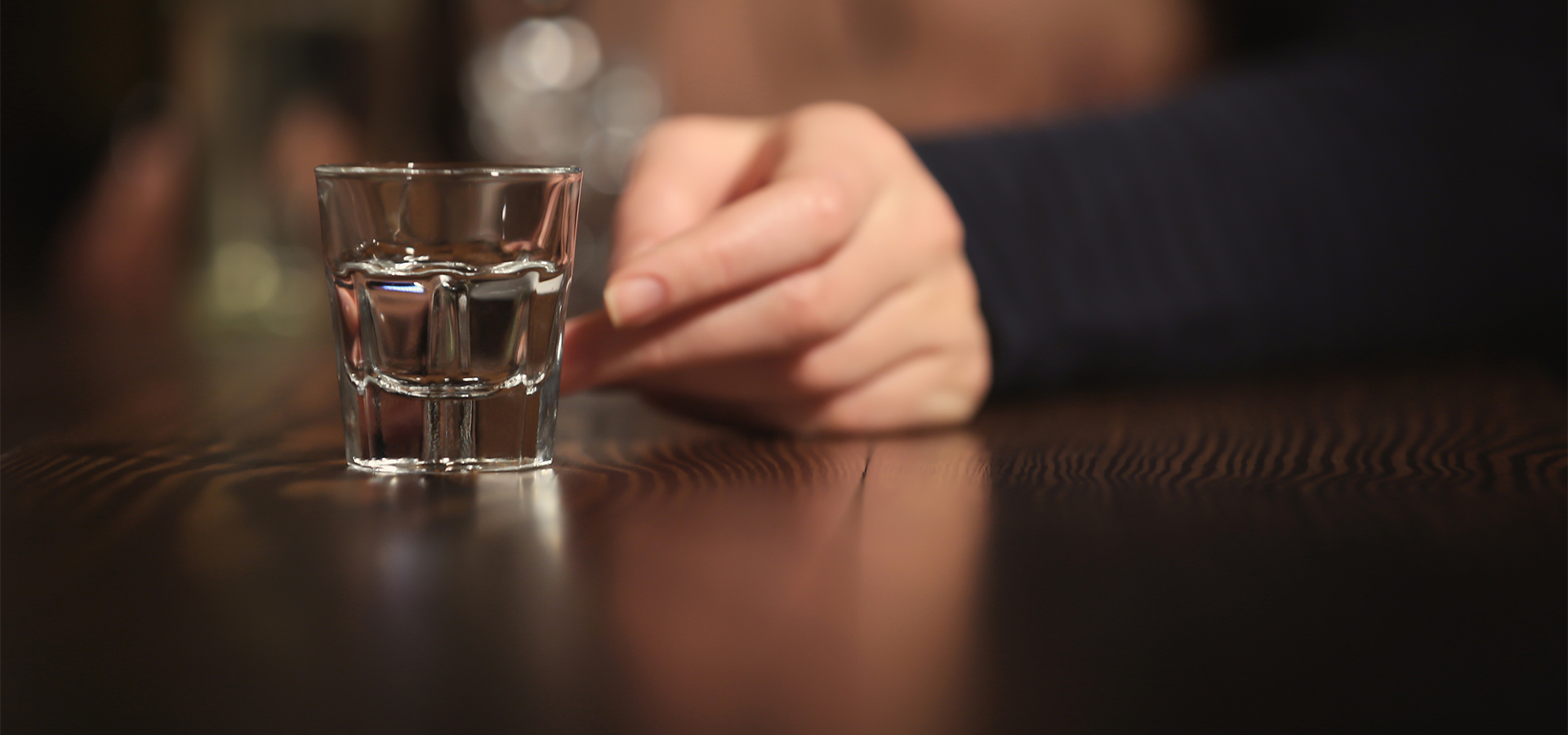 hand reaching out for shot glass