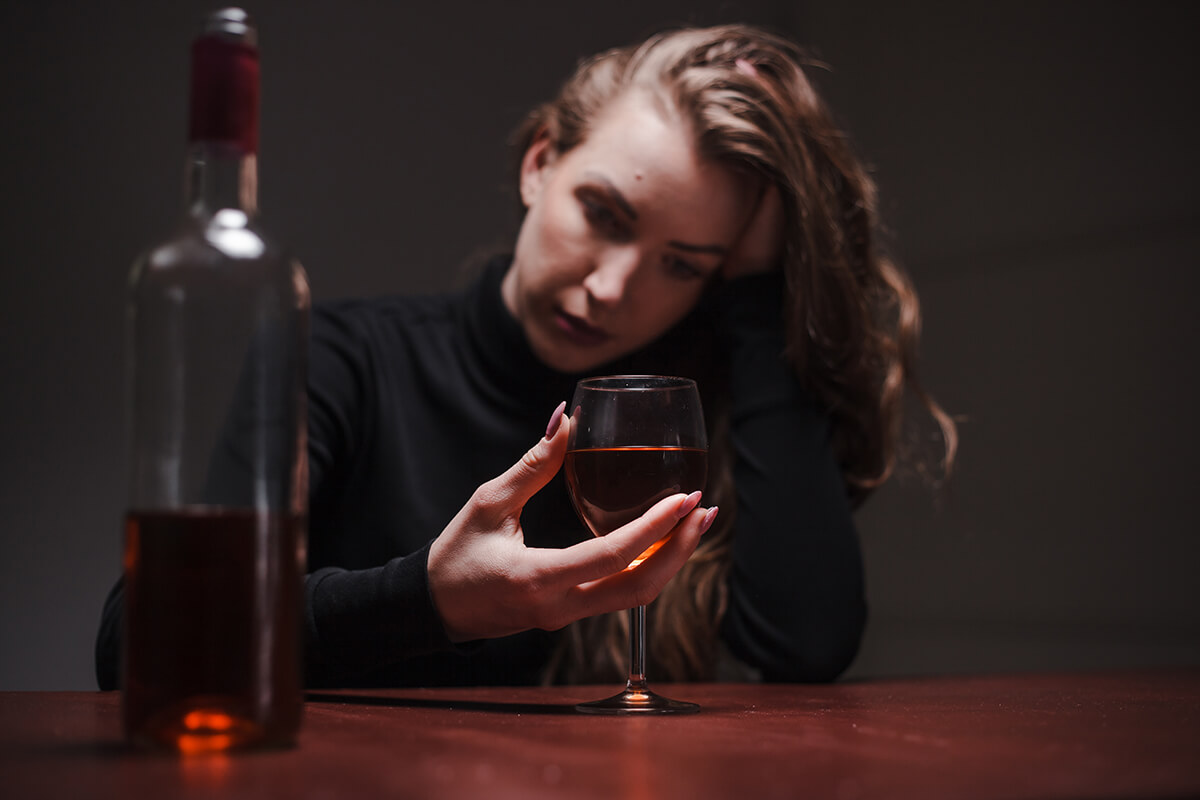 woman looking at wine glass as a high functioning alcoholic