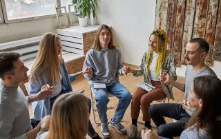 group in therapy holding hands getting addiction help