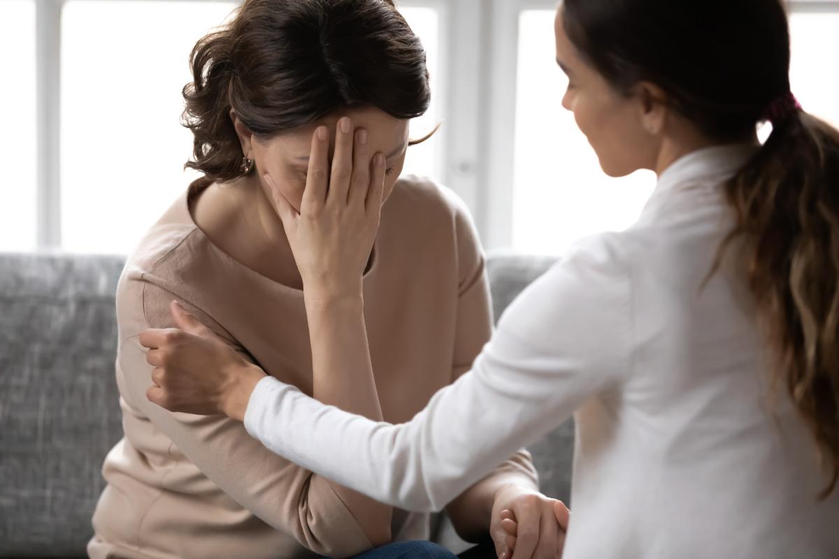 a woman comforting her friend about trauma therapy