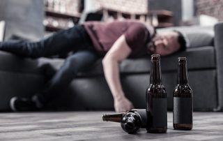 man passed out on couch showing signs of alcohol overdose