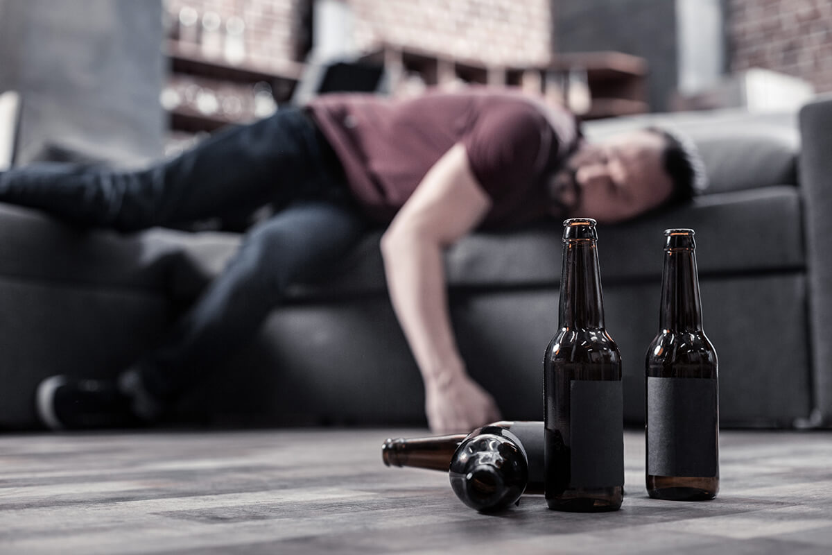 man passed out on couch showing signs of alcohol overdose