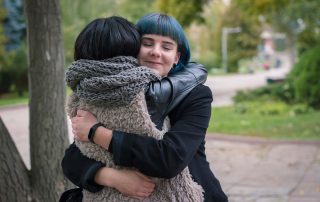 a woman hugging her friend struggling with signs of codependency