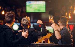 Men participating in alcohol and sports at a sports bar