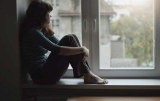women sitting on a window sill experiencing cocaine withdrawal