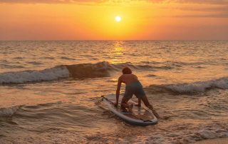 man paddle boarding in the ocean practicing sober activities