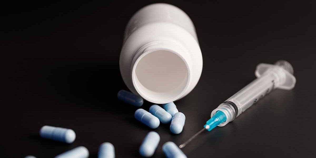 Spilt pill vile besides a syringe, signs of fentanyl abuse - Drug Paraphernalia