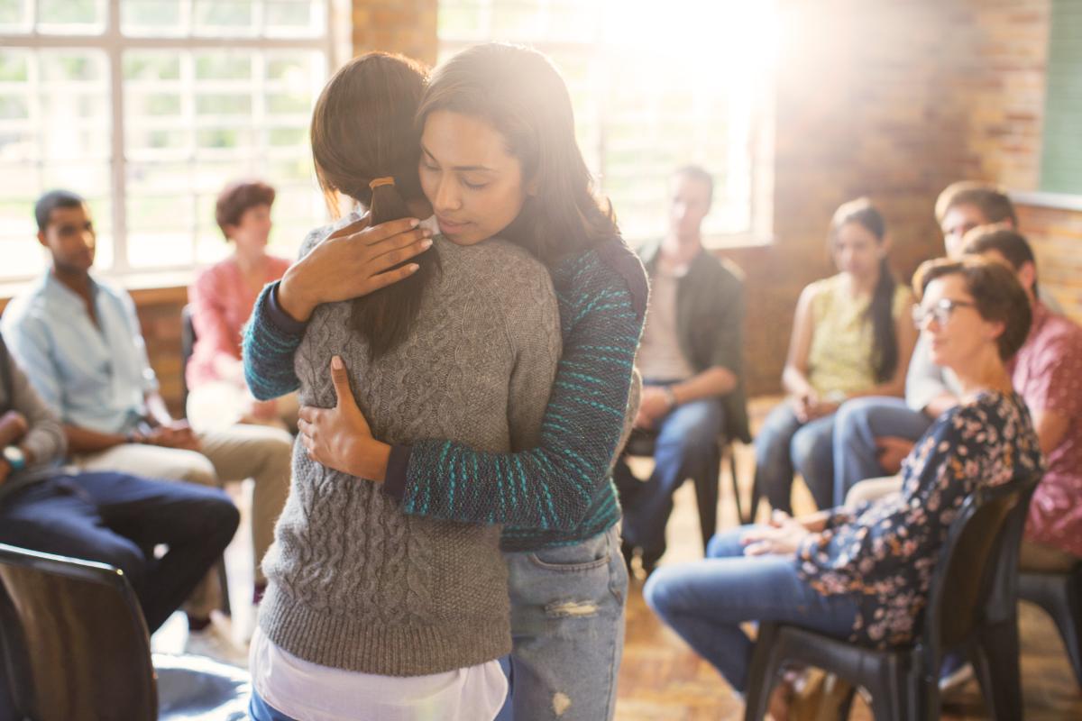 two women hugging in a 12 step program for addiction