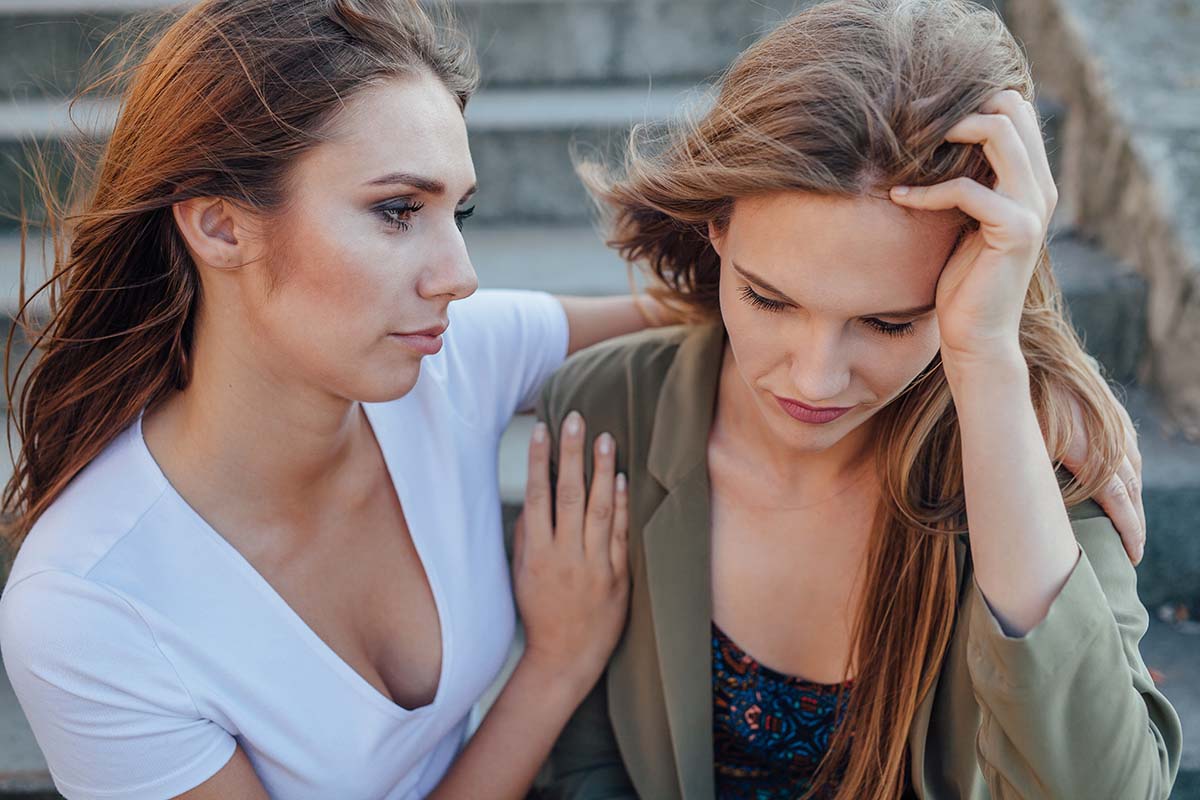 a woman displaying signs of meth addiction and being comforted by a friend