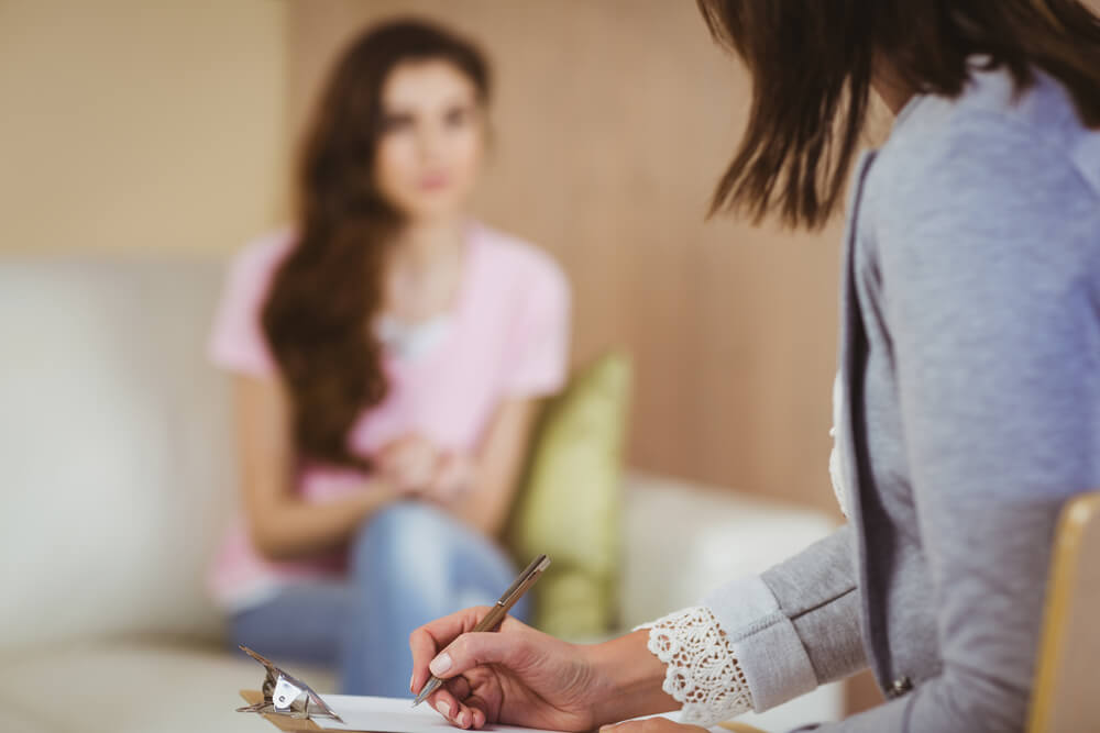 a woman talking to her doctor about joining an intensive outpatient treatment program