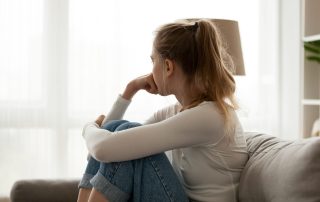 woman stressed looking out window - sober during the holidays