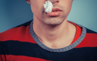 Man with bloody tissue in his nose