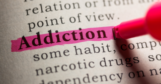 The word "addiction" highlighted in a dictionary.